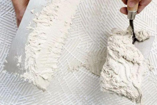 Homem utilizando argamassa para utilizar na parede
