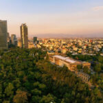 Imagem de cidade com prédios e árvores ao redor