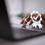 Pessoa utilizando notebook com ícones simbolizando a Falcão Bauer