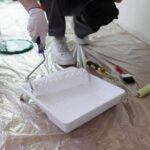 Homem com um rolo de pintura na mão, preparando uma manta líquida multiuso