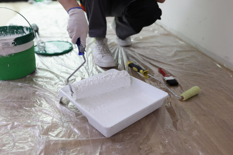 Homem com um rolo de pintura na mão, preparando uma manta líquida multiuso