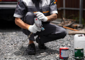 Homem aplicando primer asfáltico no chão