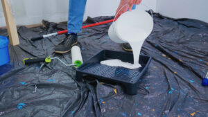 Manta líquida branca - pintor despejando manta líquida branca no recipiente de pintura